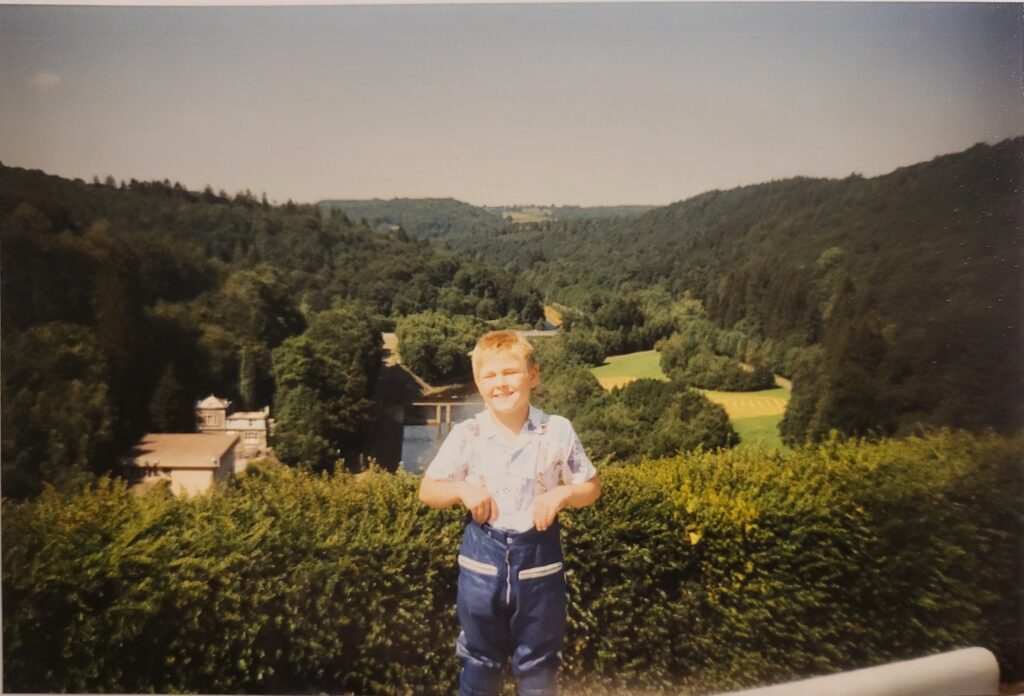 Kinderfoto eines TBM-Teilhabers vor einer Landschaft in der Eife